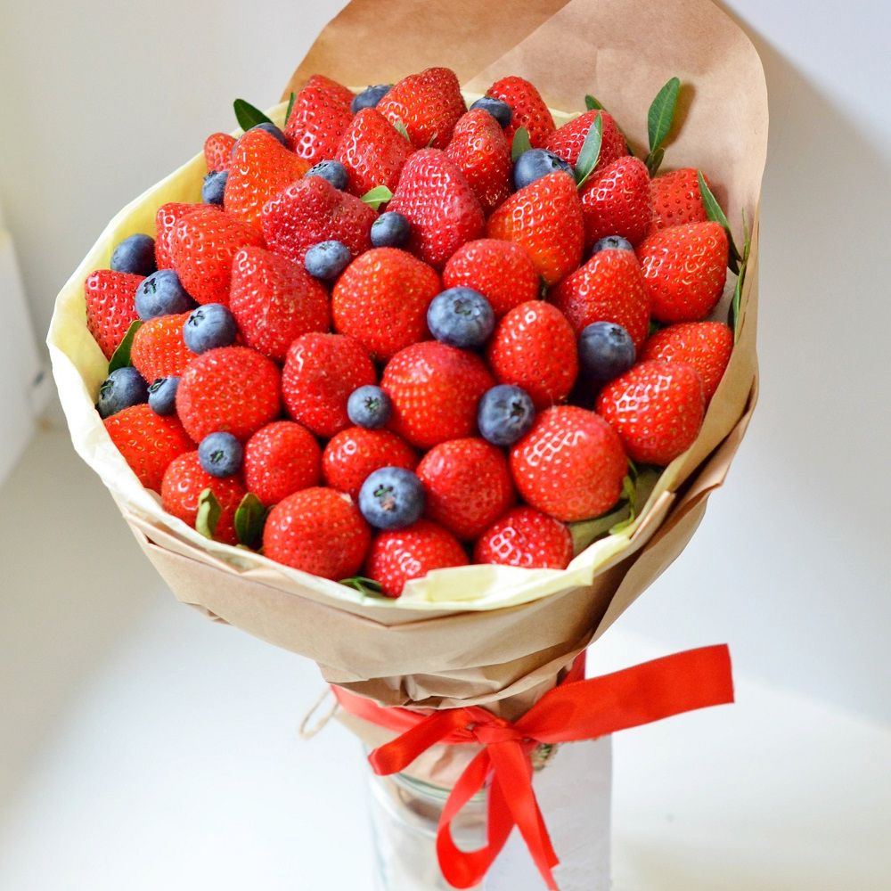 ягодный букет из клубники на шпажках с голубикой и декоративной зеленью в праздничной упаковке